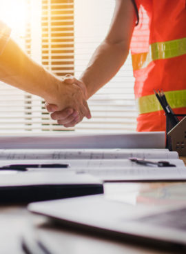Handshake of two business man, after  architect working and planning blueprint, Engineering objects on workplace