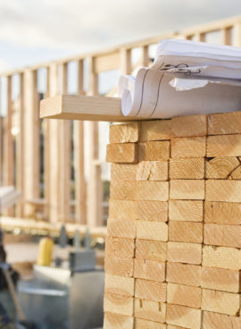 Stacked Lumber and Blueprints at a Construction Site