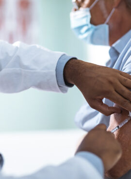 Mature man taking a vaccine from his doctor