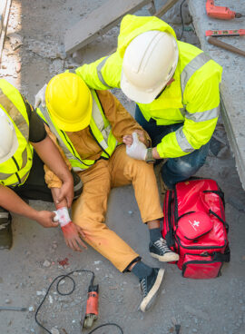 Construction worker has an accident at a construction site. Emergency help engineers provide first aid to construction workers in accidents.