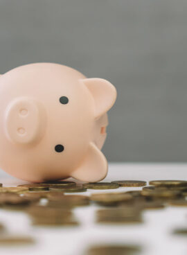 Inverted piggy bank, spilled gold coins. Opening piggy bank. Waste of accumulated money.